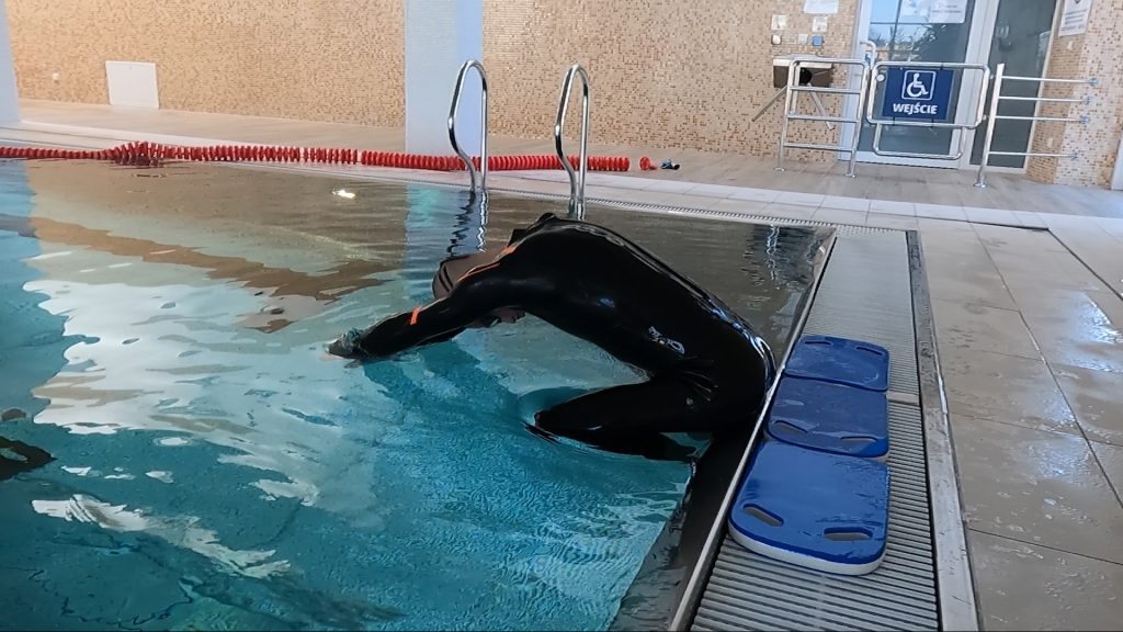 Ześlizg do wody z siadu przy ścianie basenu